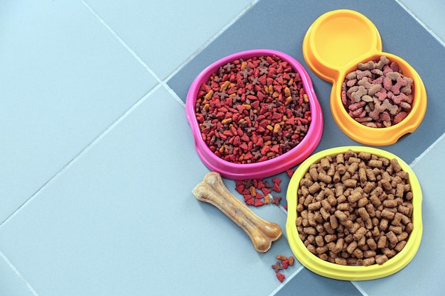 Comida para mascotas en tazones en el piso