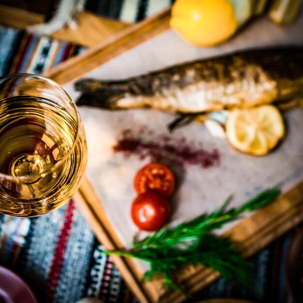 comida mediterrânea fumada peixe de arenque servido com cebola verde tomate de cerveja especiarias pão e molho Tahini em fundo escuro vista superior em close-up
