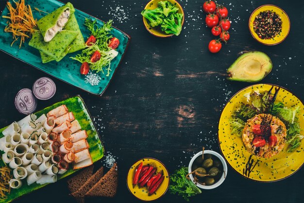 Comida en una mesa de madera Bolas de masa hervida y panqueques de espinacas y ensalada Vista superior Espacio libre para su texto