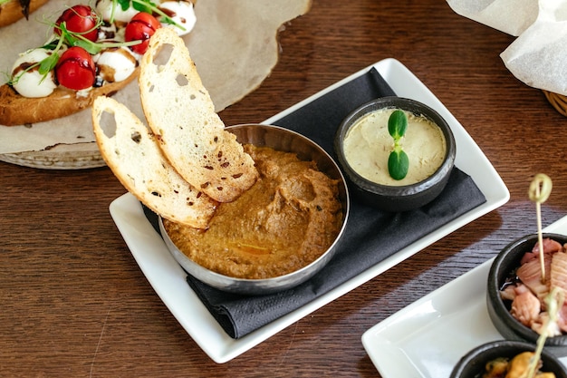 Una comida en una mesa con un plato de comida y un plato de salsa.