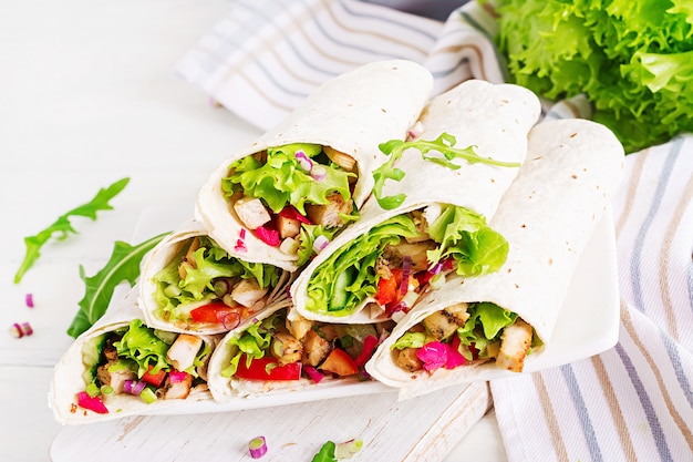 Comida mexicana de calle, fajita, tortilla con envoltura de pollo a la parrilla y verduras frescas.