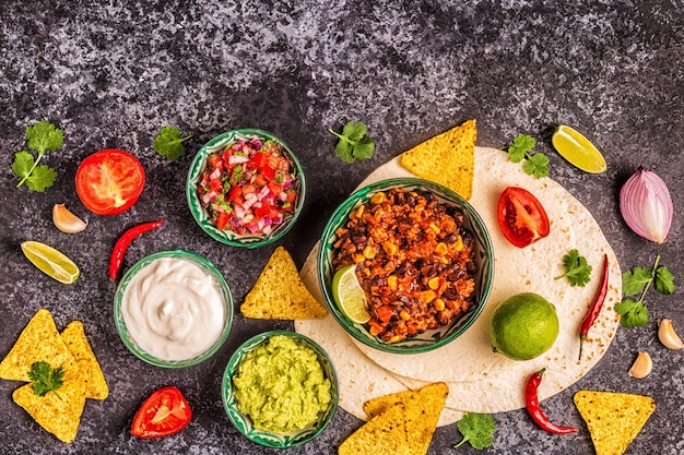 Comida mexicana com fundo de guacamole, molhos com queijo e queijo