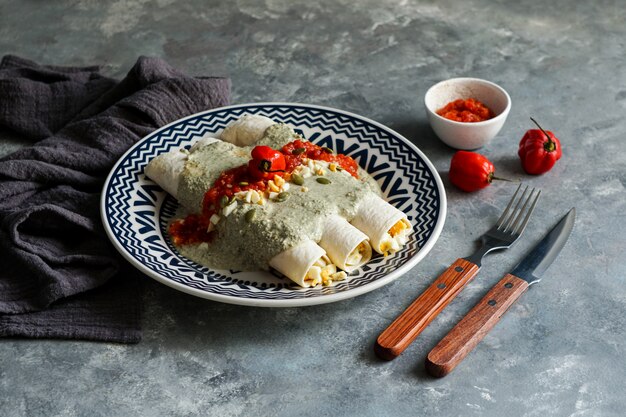 Comida mexicana, plato tradicional de Papadzules de la península de Yucatán, tortillas de maíz bañadas en salsa