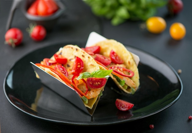 Comida mexicana Tacos picantes con tomates y carne sobre un fondo oscuro