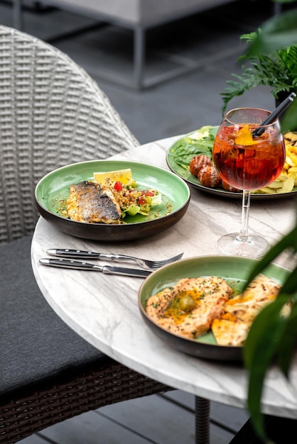 Comida na mesa terraço de verão filé de robalo grelhado e homus