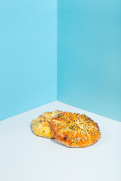 Comida nacional uzbeka tandyr pan lepeshka con queso sobre fondo azul estilo minimalista alta calidad ...