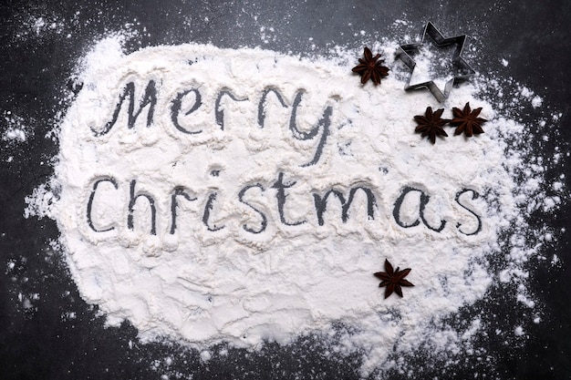 Comida navideña con la inscripción Feliz Navidad en harina esparcida