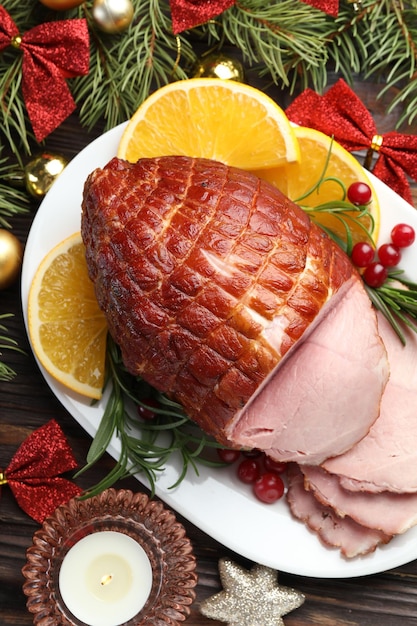 Comida navideña saboroso jamón horneado servido en una mesa de madera plana