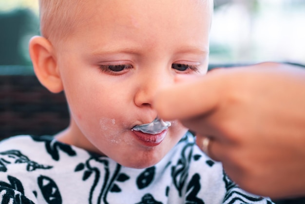 Comida para niños Alimentar a un bebé con una cuchara Paternidad madre o hermana con un niño