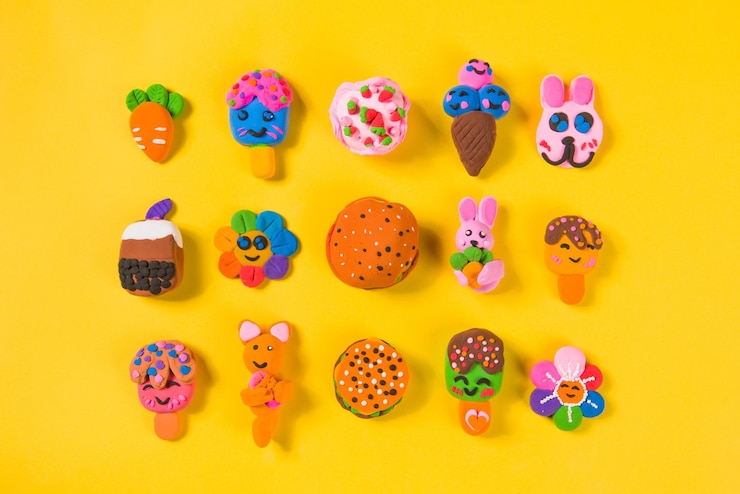 Foto comida para niños y animales con arcilla de plasticina sobre fondo amarillo