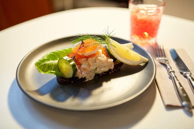 comida, nova cozinha nórdica, conceito culinário e de culinária - close-up de toast skagen com camarões, uvas de peixe e pão de manteiga no prato no restaurante