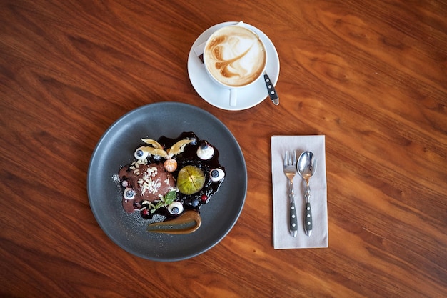 comida, nueva cocina nórdica y concepto de dulces - postre de helado de chocolate con kissel de arándano, higo horneado con miel y yogur griego en el plato en el restaurante