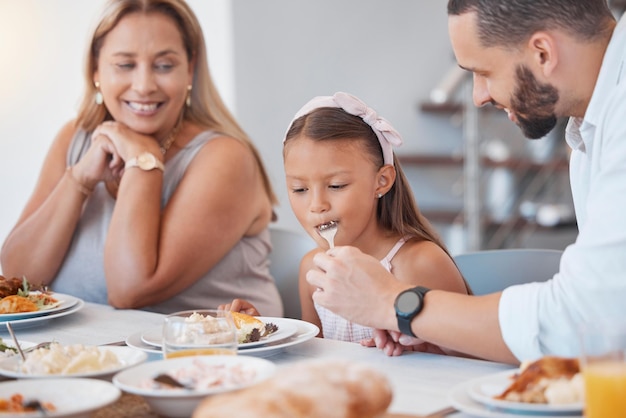 Foto comida del padre y comer con el niño mientras alimenta una dieta saludable o nutrición en el almuerzo familiar en casa el niño de la familia y la niña y la abuela hambrientas almuerzan o comen para la salud y el bienestar