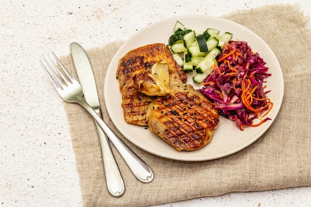 Comida Paleo saudável com carne grelhada, pepino fresco, repolho fermentado e cenoura