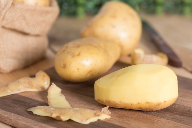 Comida de papa cruda. Patatas en una tabla de cortar.