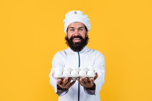 Comida de Pascua hombre guapo con barba y bigote cocinando comida restaurante profesional cocinero horneado panadero experto usar utensilios de cocina chef masculino con sombrero preparar comida saludable eres lo que comes