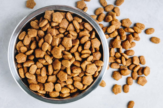 Comida para perros Comida seca para perros en un tazón sobre fondo de piedra gris