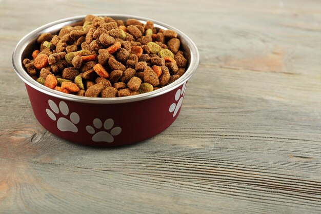 Comida para perros en un tazón en la mesa de madera