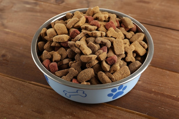 Comida para perros en un tazón en la mesa de madera