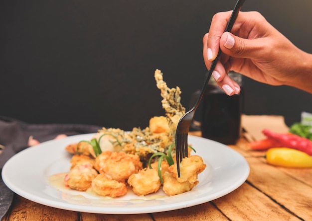 Comida peruana Camarones salteados con hierbas y ajo mesa de madera servida en un plato blanco