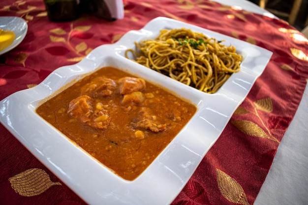 Comida peruana SOPA SECA CON CARAPULCRA, comidas tradicionales en platos blancos dobles.