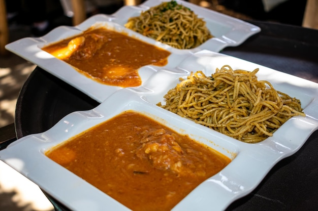 Comida peruana SOPA SECA CON CARAPULCRA, comidas tradicionales en platos blancos dobles.