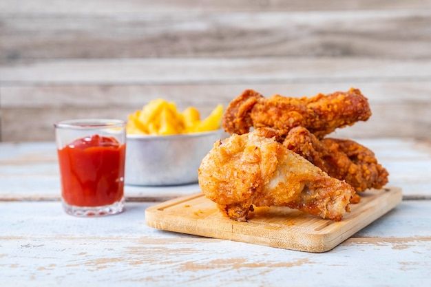 Comida de pollo frito y papas fritas en una mesa de madera