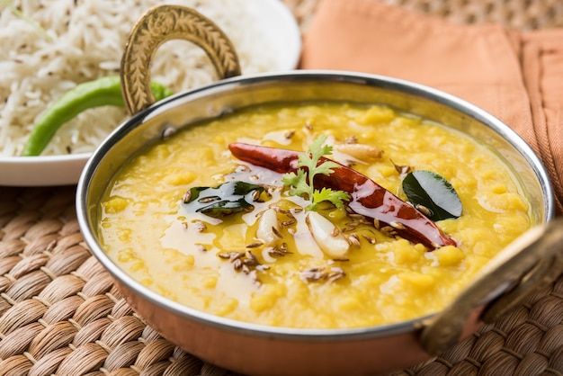 Comida popular india Dal fry o curry Dal Tadka tradicional servido con arroz jeera, aislado sobre fondo blanco, enfoque selectivo