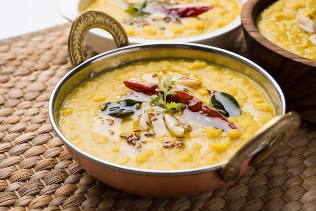 Comida popular india Dal fry o curry Dal Tadka tradicional servido en un recipiente, aislado sobre fondo blanco, el enfoque selectivo