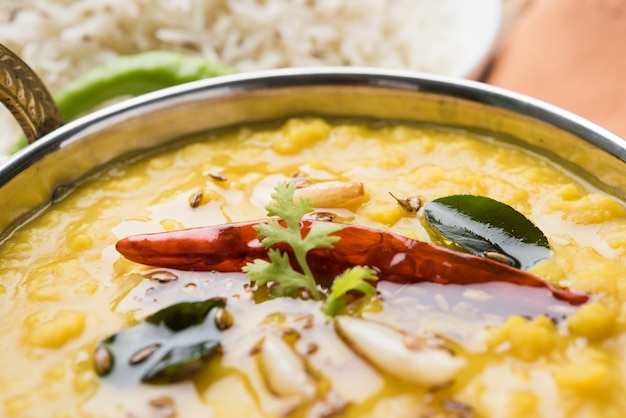 Comida popular indiana dal fry ou o tradicional dal tadka curry servido com arroz jeera, isolado sobre fundo branco, foco seletivo