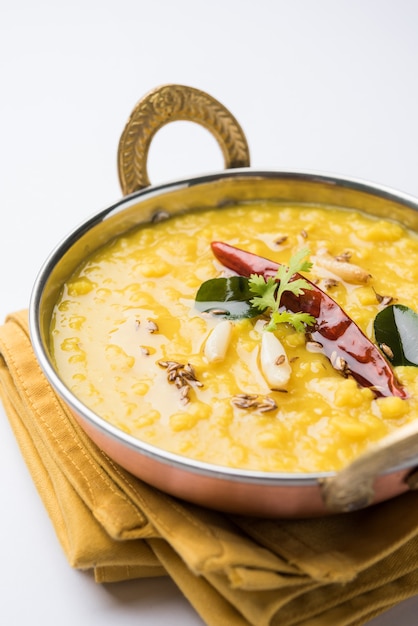 Comida popular indiana Dal fry ou o tradicional Dal Tadka Curry servido em uma tigela, isolado sobre um fundo branco, com foco seletivo