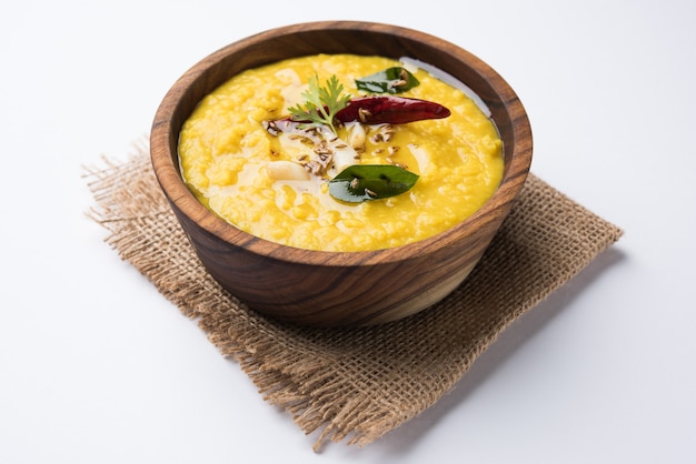 Comida popular indiana Dal fry ou o tradicional Dal Tadka Curry servido em uma tigela, isolado sobre um fundo branco, com foco seletivo
