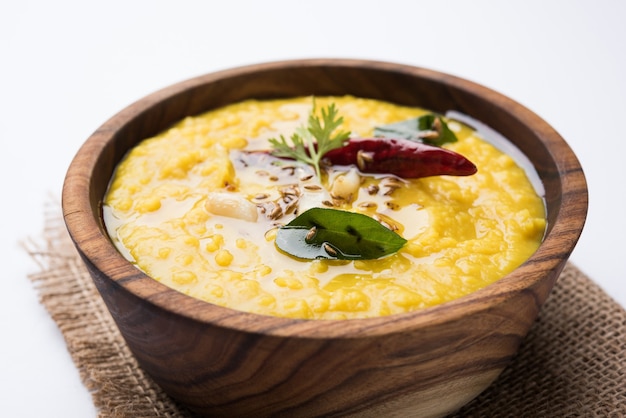 Comida popular indiana Dal fry ou o tradicional Dal Tadka Curry servido em uma tigela, isolado sobre um fundo branco, com foco seletivo