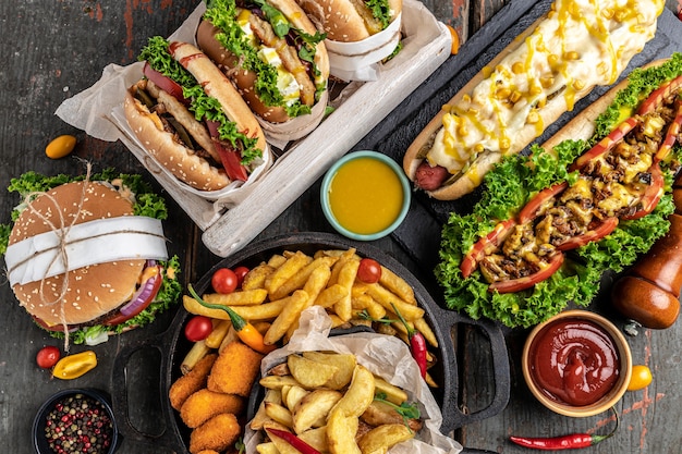 Comida rápida americana. Hamburguesas, papas fritas, perritos calientes. comida rápida y concepto de alimentación poco saludable. vista superior