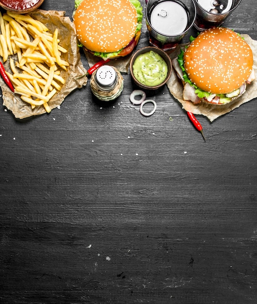 Comida rápida. Hambúrgueres com batata frita e coca-cola. No quadro negro.