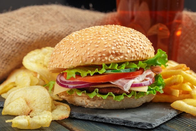 Comida rápida, hamburguesa casera sobre fondo de madera.