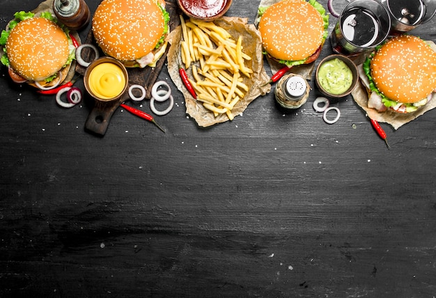 Comida rápida. Hamburguesas con papas fritas y cola. En la pizarra negra.