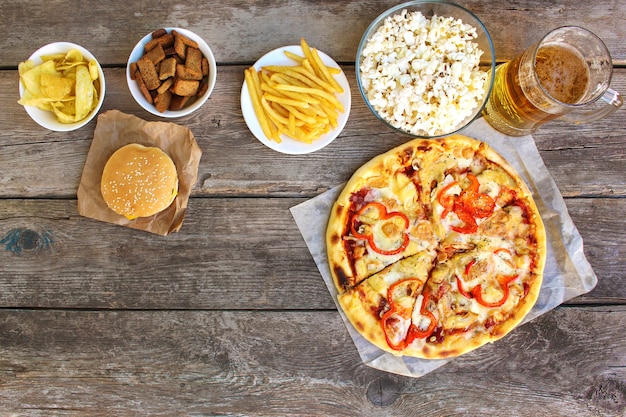 Comida rápida sobre fondo de madera vieja. Concepto de comida basura. Vista superior.