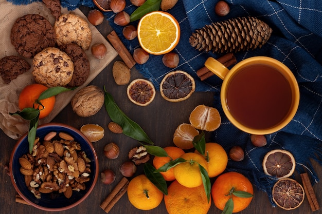 Comida reconfortante de invierno: galletas de chocolate, nueces, mandarinas y té