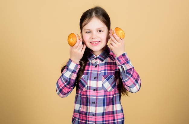 Comida y refrigerio simple y dulce Niño pequeño lindo que sostiene en las manos comida casera de magdalenas Adorable niña pequeña con comida de postre recién horneada La comida azucarada más tentadora