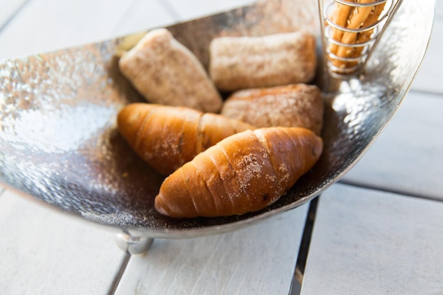 comida, repostería, comida chatarra y concepto de alimentación poco saludable - cierre de bollos en un tazón en la cafetería o panadería