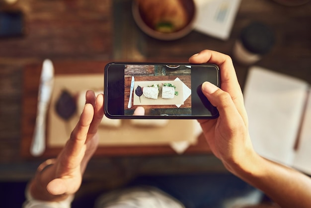 Comida de restaurante y manos con pantalla de teléfono para fotografía de imágenes y documentación de la experiencia culinaria Por encima de la persona y la aplicación móvil con cámara para la revisión y publicación de platos de sándwich para las redes sociales