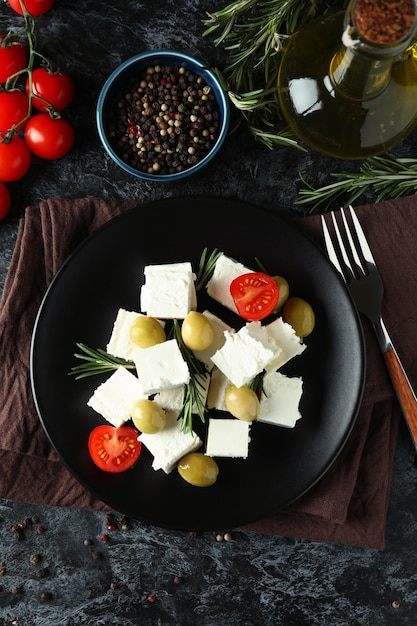 Comida saborosa com queijo feta em superfície preta esfumada