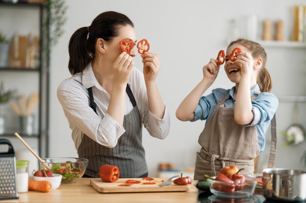 Comida saludable en casa Familia feliz en la cocina Madre e hija están preparando una comida adecuada