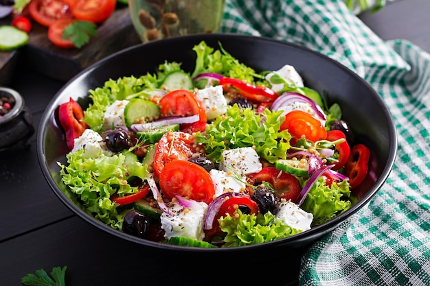 Comida saludable ensalada griega con pepino tomate pimienta dulce lechuga cebolla roja queso feta y aceitunas