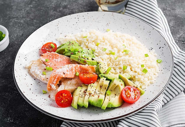 Comida saludable. Ensalada de salmón, cuscús, aguacate y tomates.