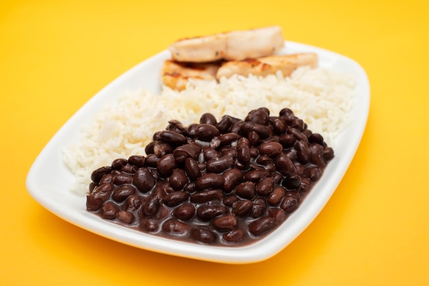 Comida saludable con frijoles de pechuga de pollo y arroz en un plato blanco