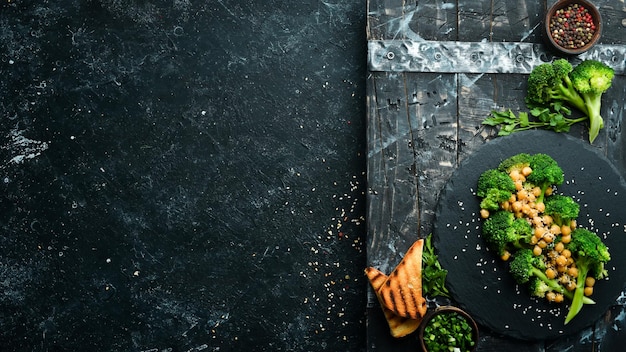 Comida saludable Garbanzos de brócoli a la parrilla y sésamo en un plato de piedra negra Vista superior Espacio libre para texto