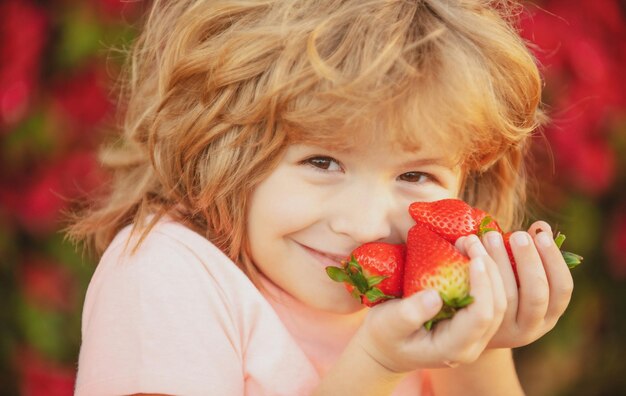 Comida saludable para niños Adorable niño comiendo fresa