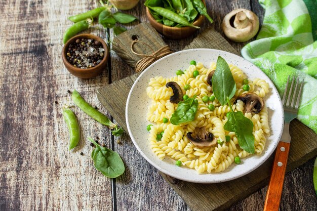 Comida saludable Pasta casera fusilli con guisantes y champiñones a la parrilla Copiar espacio